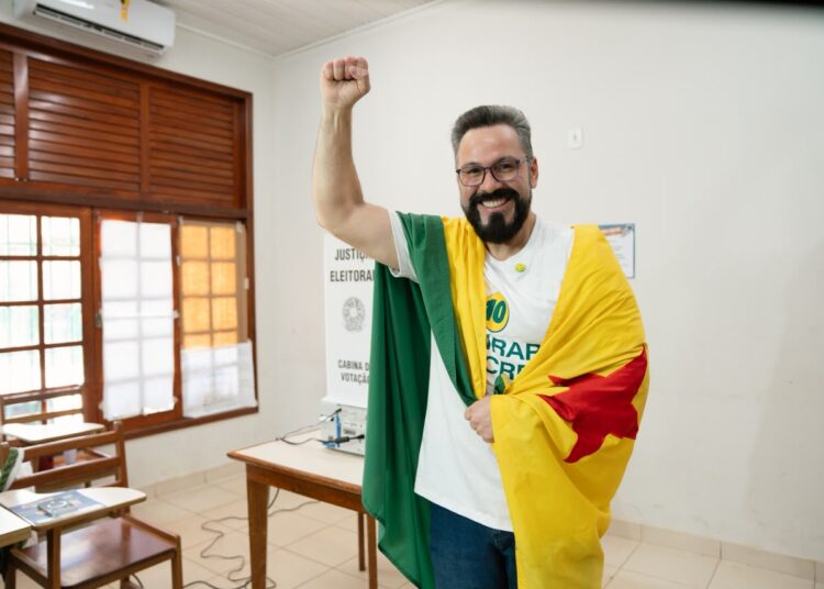 Alan vota com bandeira do Acre nas costas: “1º turno, se Deus quiser”