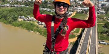 Bombeira mostra desafios para trocar bandeira a mais de 50 metros de altura em Ponte da União, em Cruzeiro do Sul